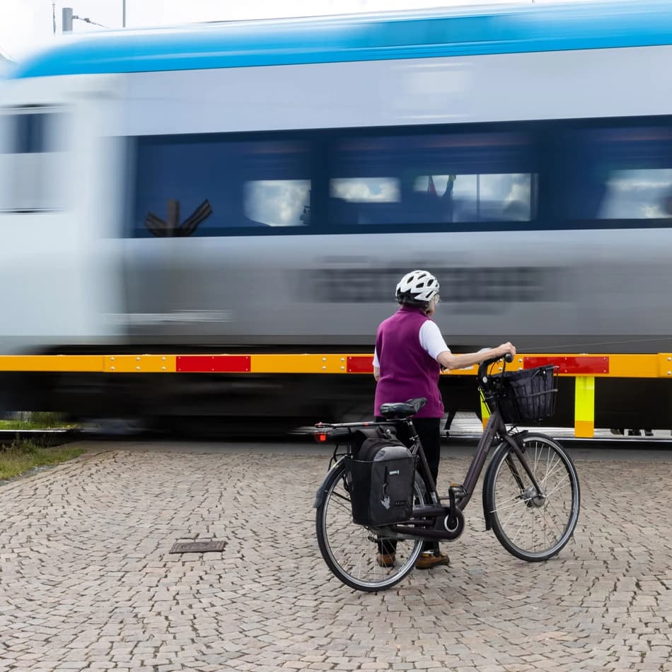 Kvinna med cykel vid järnvägsövergång vid hamnen den 15 juni 2022 i Jönköping. Genre Sverige Makro inflation BNP 
